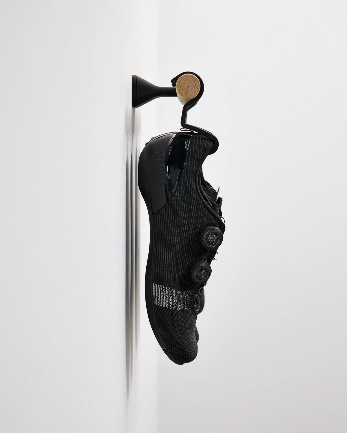 ナチュラルオークの Short Bar C に黒いサイクルシューズ1ペアを掛けた側面ディスプレイ