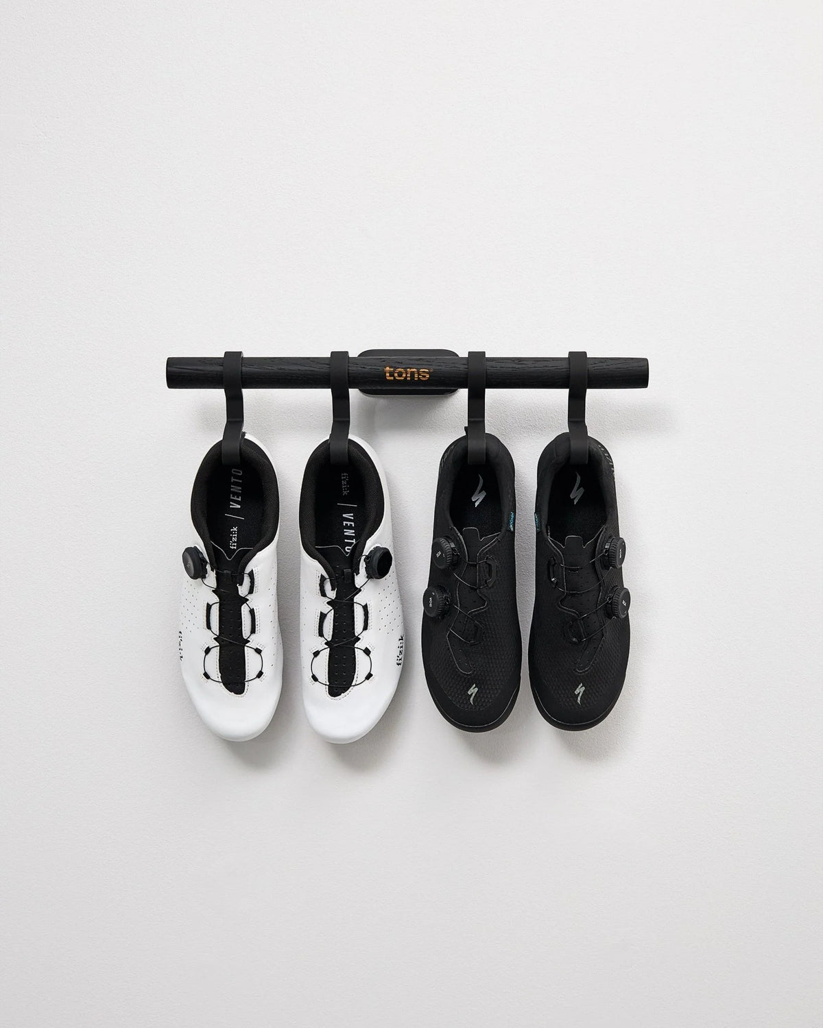 マットブラックの Short Bar C に白いシューズ1ペアと黒いシューズ1ペアを整然と掛けた写真
