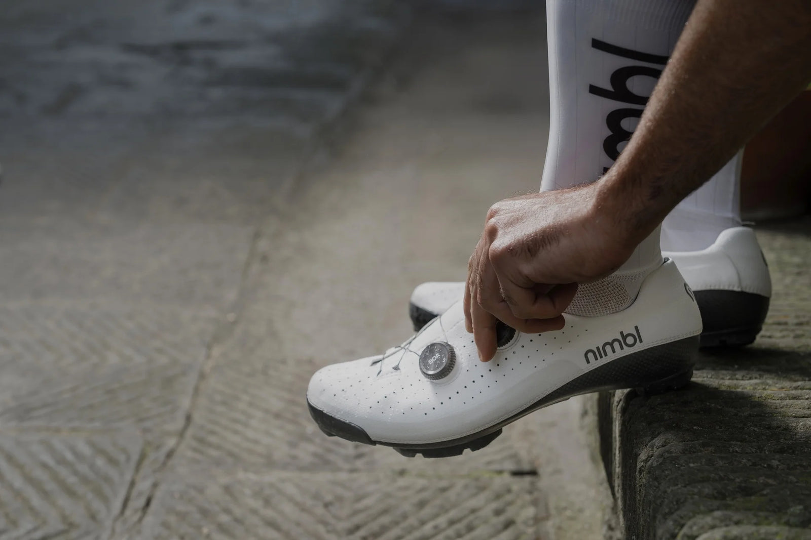 NIMBL Urano グラベルシューズ（ホワイト）、BOAダイヤル調整中のクローズアップ、イタリア製ハンドメイド仕様